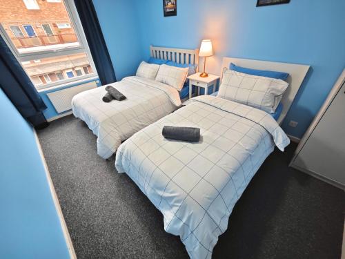 two beds in a room with blue walls at 2 Bedroom Flat Next to Lord's Cricket Ground, Central London in London