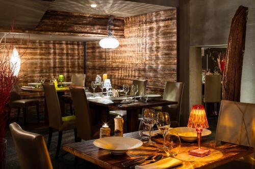 a restaurant with wooden tables and chairs with glasses on them at Hotel Pashmina Le Refuge in Val Thorens