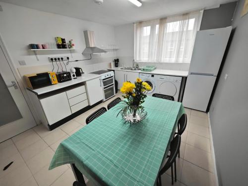 a kitchen with a table with a vase of flowers on it at 2 Bedroom Flat Next to Lord's Cricket Ground, Central London in London