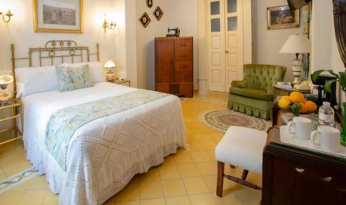 a bedroom with a bed and a chair and a table at Grand Casa Naranjos, Hospedaje Alteño in Tepatitlán de Morelos