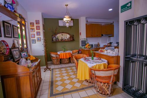 a dining room with two tables and a kitchen at Grand Casa Naranjos, Hospedaje Alteño in Tepatitlán de Morelos