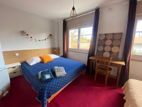 une chambre avec un lit, une table et une fenêtre dans l'établissement Au Vélo Bleu - Privatisez un ancien hôtel entre lac océan - 12pers, à Soustons