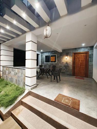 a living room with a table and a television at Kamoga Homestay in Virajpet