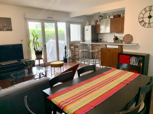 a living room with a table and a kitchen at Appartement calme avec jardin in Bruges