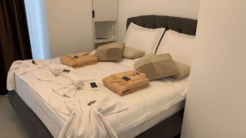 a white bed with two bags on top of it at Oltenia Studio Decebal Residence Craiova in Craiova