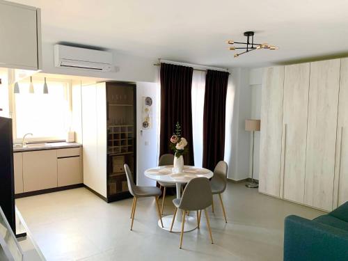 ein Wohnzimmer mit einem weißen Tisch und Stühlen in der Unterkunft Oltenia Studio Decebal Residence Craiova in Craiova