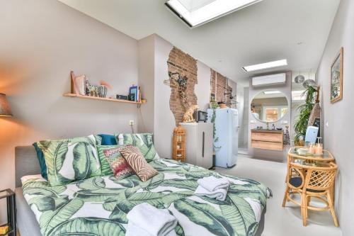 a bedroom with a bed and a kitchen at Pats garden room with mini cinema, projector in Alkmaar