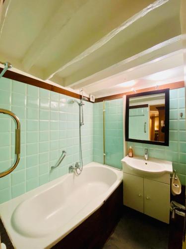 une salle de bain avec une baignoire et un lavabo dans l'établissement Appartement Musée du Louvre Paris, à Paris
