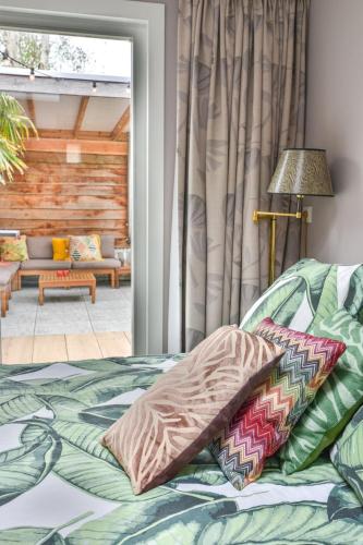 a bed with pillows on it in a room at Pats garden room with mini cinema, projector in Alkmaar