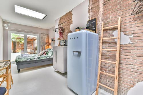 a room with a refrigerator and a brick wall at Pats garden room with mini cinema, projector in Alkmaar