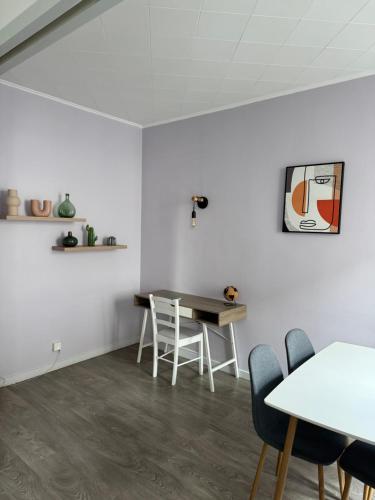 une chambre blanche avec une table et des chaises. dans l'établissement Appartement T4 70m2 - meublé - centre ville - proche Thermes, à Lons-le-Saunier