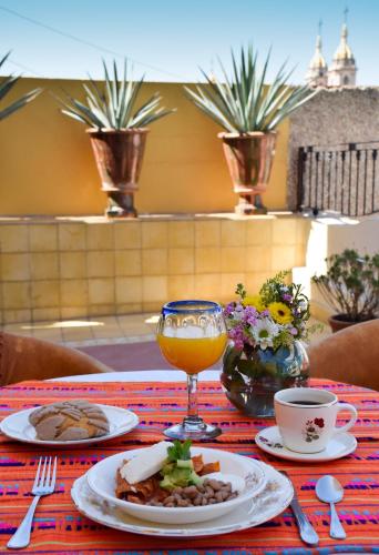 a table with a plate of food and a drink at Grand Casa Naranjos, Hospedaje Alteño in Tepatitlán de Morelos