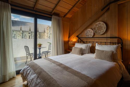 a bedroom with a large bed and a large window at Mater Hotel in Canela