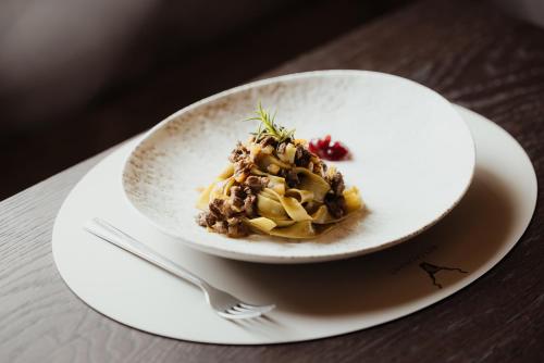 a white plate with food on a table at Hotel Jägerhof in Colfosco