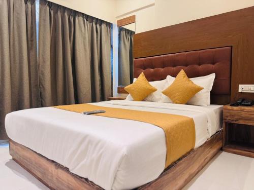 a bedroom with a large bed with yellow pillows at Hotel West Line Andheri in Mumbai