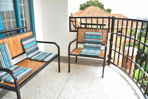 two chairs sitting on a balcony at Sam's Villa in Kigo