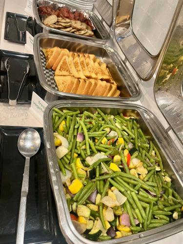 a buffet filled with different types of vegetables in trays at Holiday Inn Orlando International Airport by IHG in Orlando