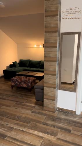 a living room with a couch and a mirror at Apartmani Kovačević MKM Banja Vrujci in Gunjica