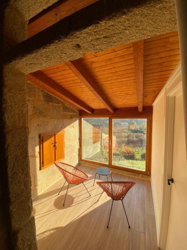 a room with two chairs and a large window at Quinta Pazo Corisca in Salceda