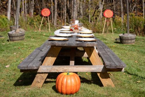 a wooden picnic table with a pumpkin on the grass at Belleayre Mountain House in Arkville