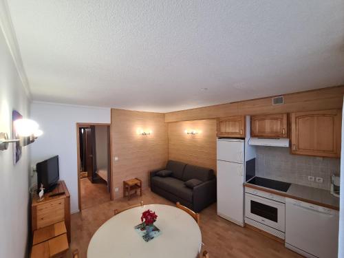 une cuisine et un salon avec une table et un canapé dans l'établissement ETOILE DES NEIGES, à Orcières