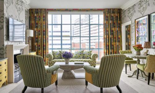 a living room with chairs and a table and a large window at Warren Street Hotel in New York
