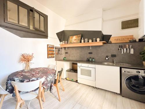 une petite cuisine avec une table et un évier dans l'établissement Palma - charmant T3 dans le centre historique, à Montpellier