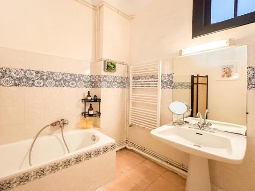une salle de bain avec une baignoire et un lavabo et une baignoire dans l'établissement Palma - charmant T3 dans le centre historique, à Montpellier