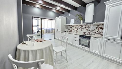 une cuisine avec une table et des chaises dans une pièce dans l'établissement Penthouse in Almaty!, à Almaty