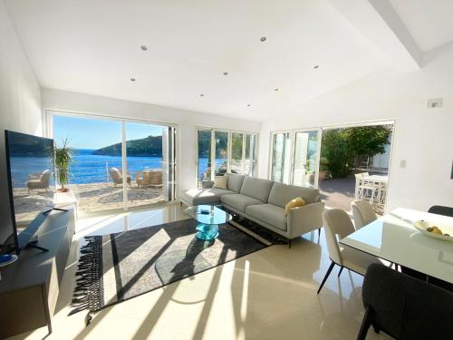 a living room with a couch and a view of the ocean at Villa Moro: Beachfront Privacy in Trstenik
