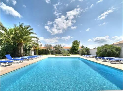 a swimming pool with blue lounge chairs and a pool at ÎLE D OLÉRON Charmante Maison Oléronaise & Piscine chauffée in Saint-Georges-dʼOléron