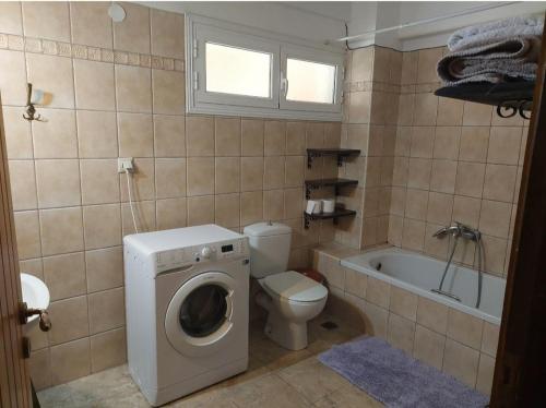 a bathroom with a washing machine and a toilet at Angelos House in Ýpsos