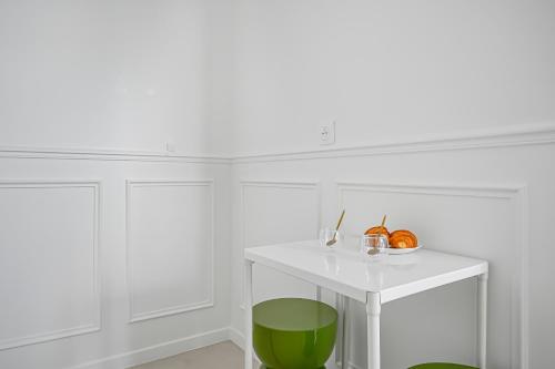 a white room with a green and white table at JIJI Suites in Combs-la-Ville