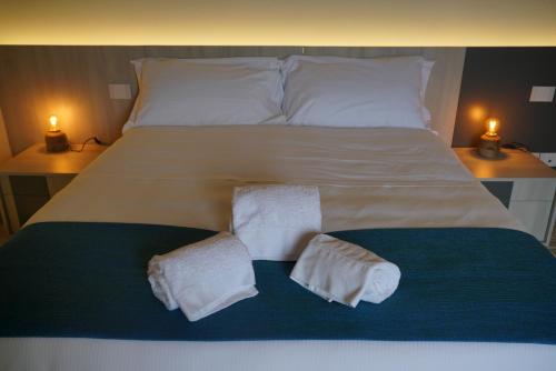 a large bed with two towels on top of it at 5 Elementi Sassi Matera in Matera
