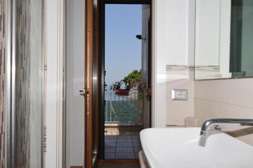 Un baño con lavabo y vista a un balcón. en Casa Mike, en Meta