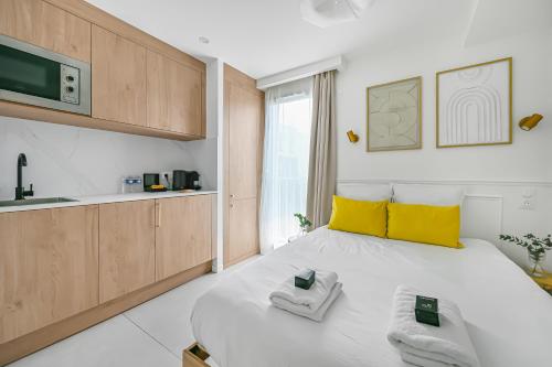 a bedroom with a large white bed with yellow pillows at JIJI Suites in Combs-la-Ville