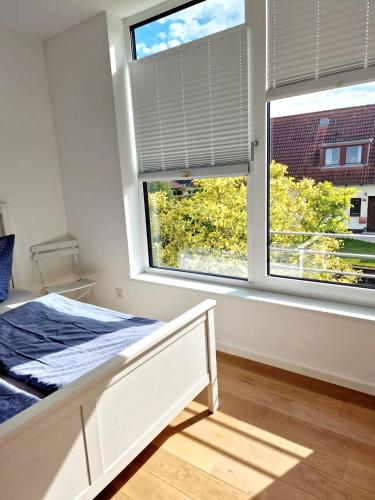 a bedroom with a bed and a large window at Fjordhaus Schleiwind in Fahrdorf