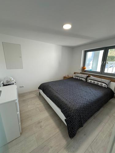 a bedroom with a bed and a window at Moderne FerienWohnung NeuBau Merzig in Merzig