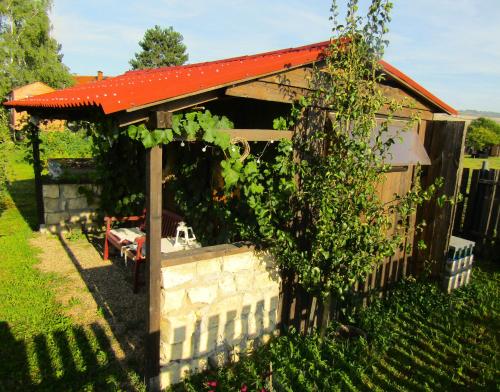 a small building with a red roof and a fence at Maringotka Matylda in Libčeves