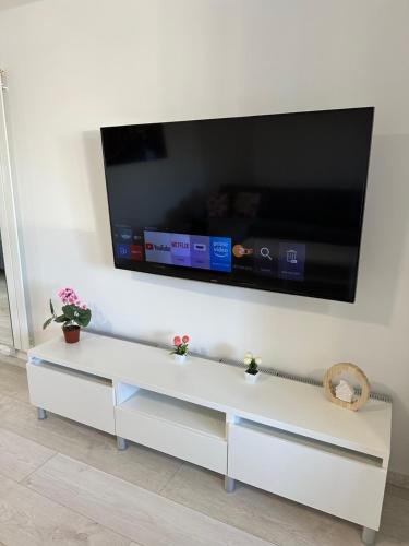 a white cabinet with a tv on a wall at Moderne FerienWohnung NeuBau Merzig in Merzig