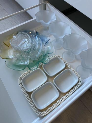 a drawer filled with white dishes and a glass plate at Moderne FerienWohnung NeuBau Merzig in Merzig