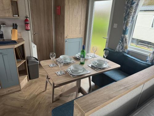 a living room with a table with plates and wine glasses at Home from Home Lettings at Tattershall Lakes - Bull Rush in Tattershall