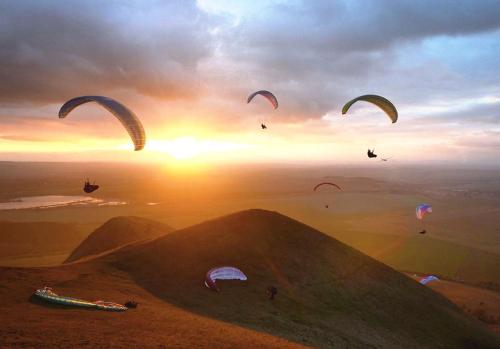 a group of people flying kites in the sky at Maringotka Matylda in Libčeves