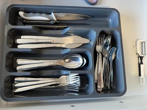 a tray filled with silver utensils sitting on a counter at Moderne FerienWohnung NeuBau Merzig in Merzig