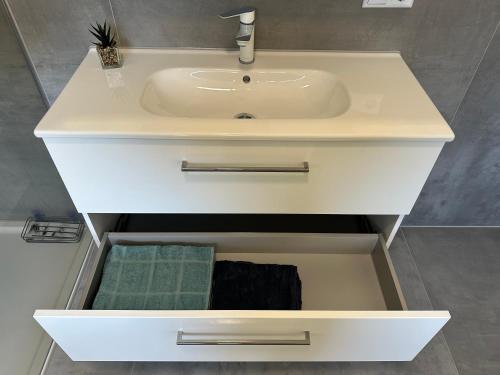 a white sink in a bathroom with a sink at Moderne FerienWohnung NeuBau Merzig in Merzig