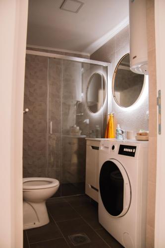a bathroom with a toilet and a washing machine at Blue Apartment in Sombor