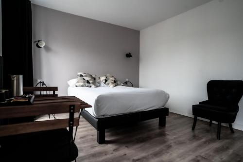 a bedroom with a bed and a desk and a chair at Hotel De Quebec in Rouen
