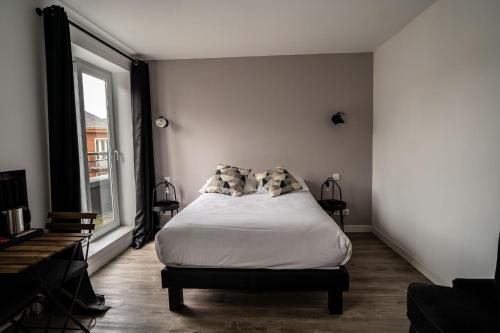 a bedroom with a bed with pillows and a window at Hotel De Quebec in Rouen