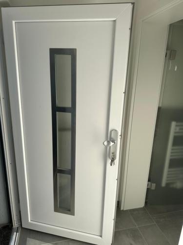 a white door with a mirror in a room at Moderne FerienWohnung NeuBau Merzig in Merzig