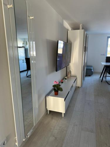 a living room with a tv and a table and a mirror at Moderne FerienWohnung NeuBau Merzig in Merzig